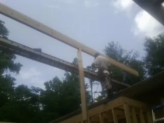 Carpenter setting a ridge beam over a new addition frame — Ice Dam Removal by Roofing Brothers in Windber