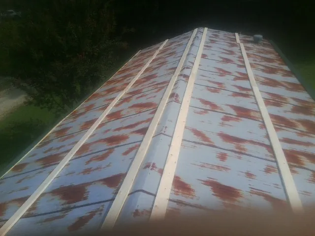Rusted metal roof panels with new wood purlins before replacement — Storm Damage Roof Repair in Windber by Roofing Brothers
