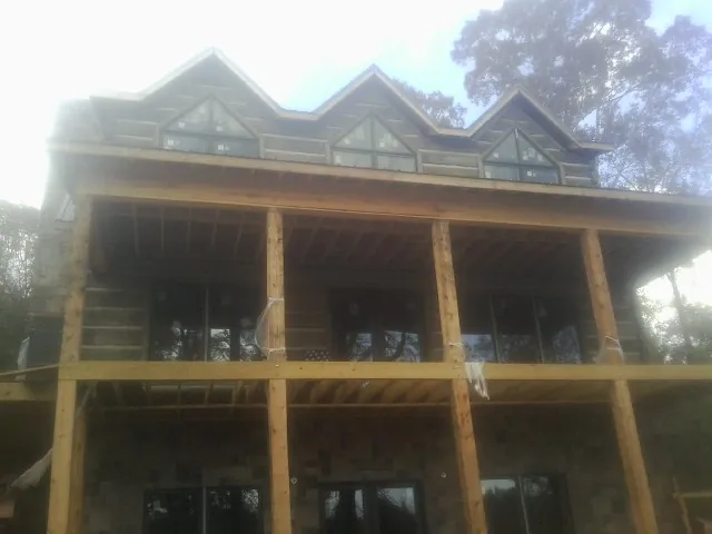 Dormers and porch framing on a large log home under construction — Roof Coating work by our crew in Windber
