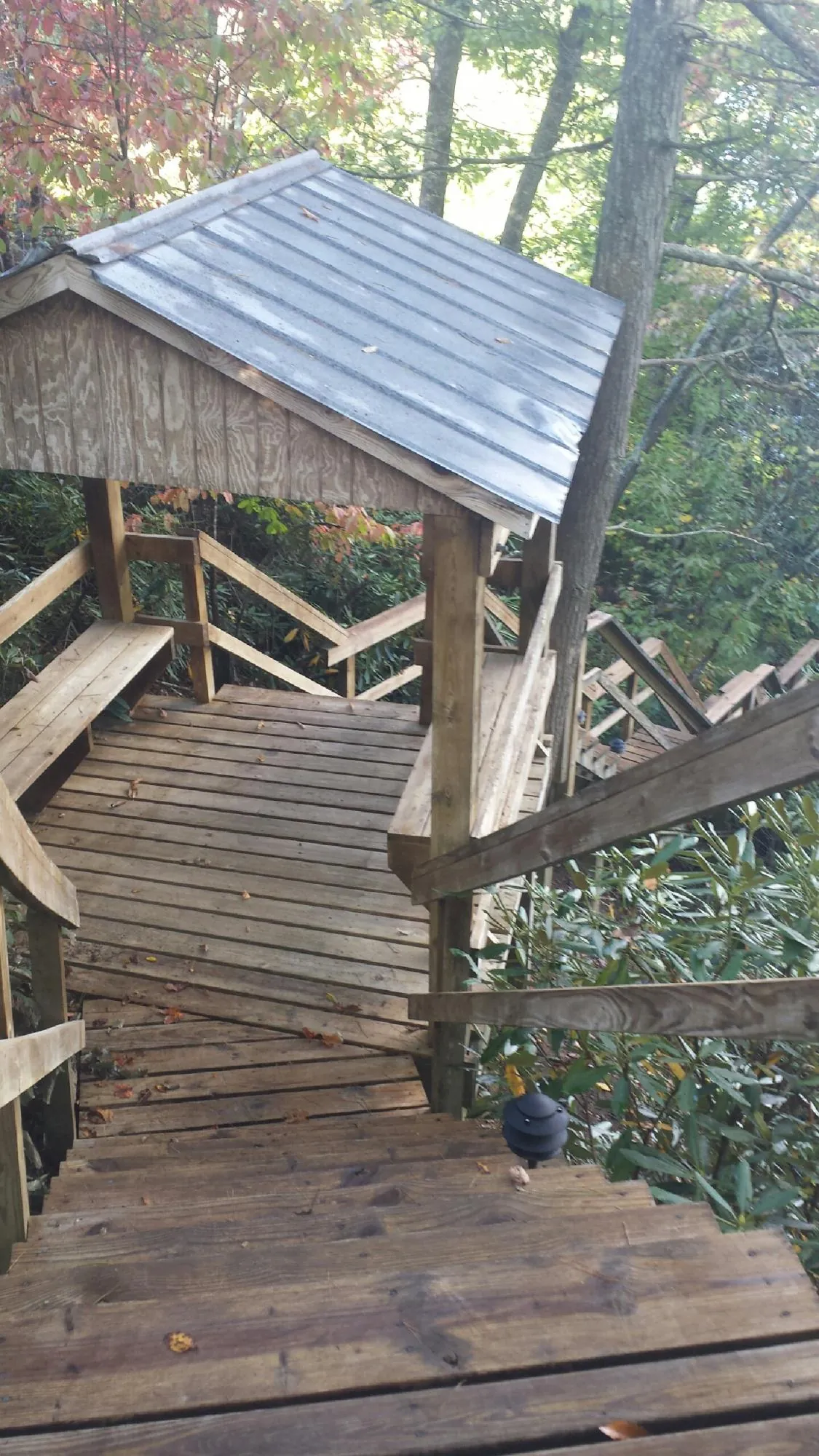 Metal roofed shelter over wooden steps on a wooded walkway — Skylight Repair & Installation work by our crew in Windber